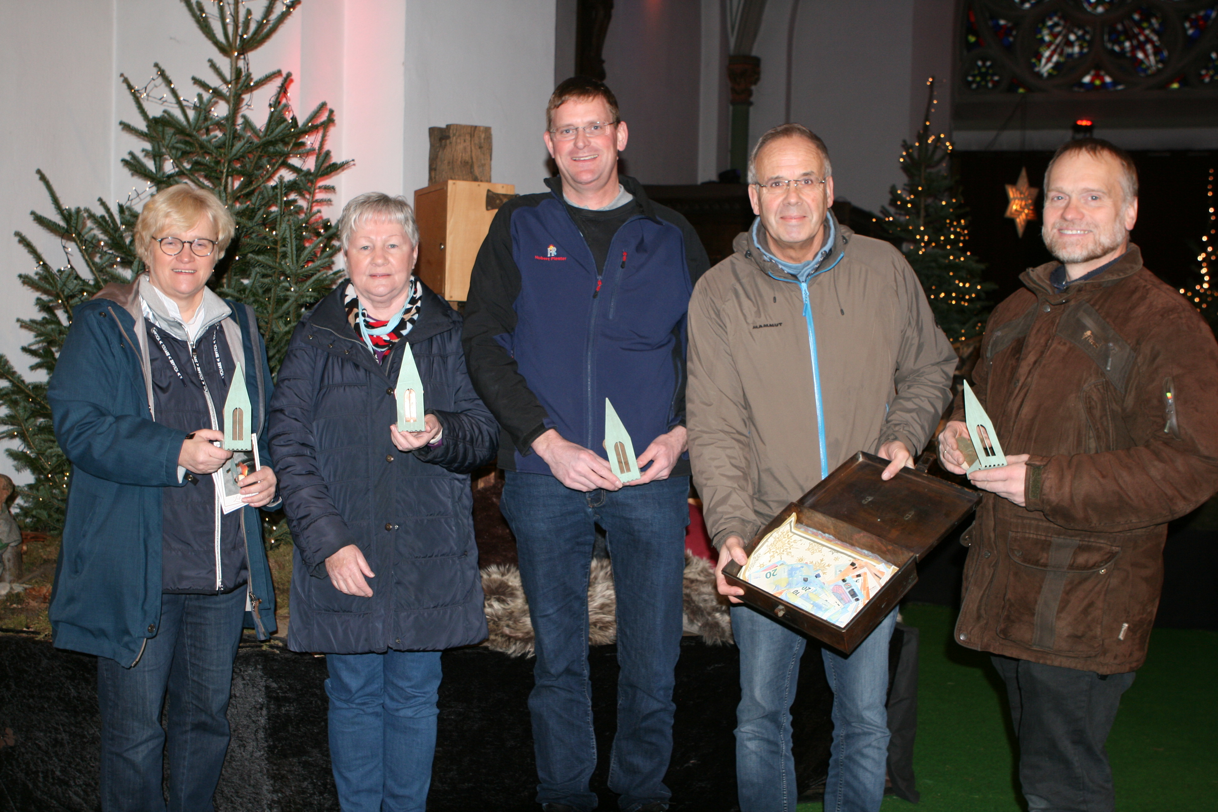 Übergabe des Erlöses vor der Krippe in Herz-Jesu