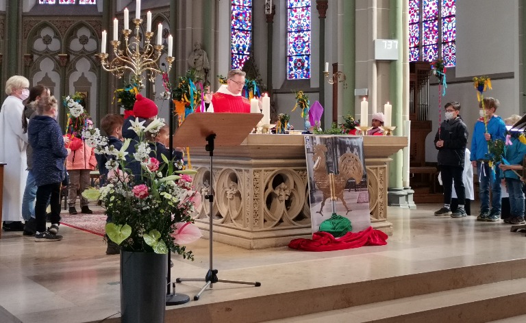 Kinder mit den Palmstöcken rund um den Altar