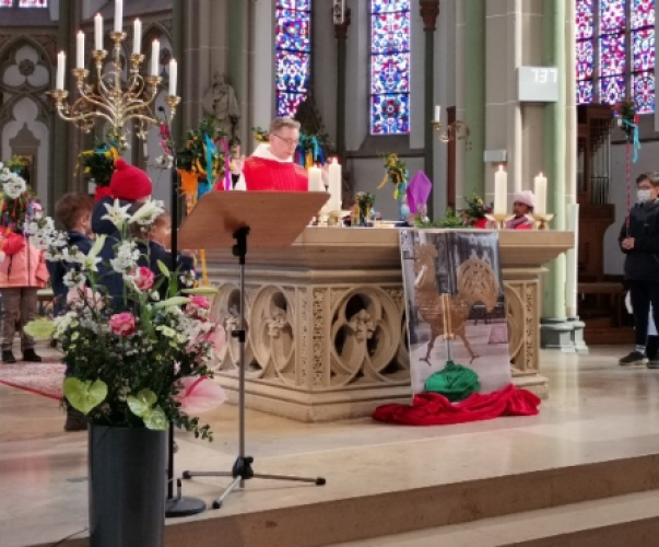 Kinder mit den Palmstöcken rund um den Altar